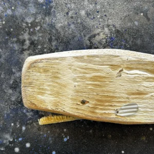 Dettaglio del capo della balena Moby Cordiale in legno chiaro con spazzolino da denti come fanoni e pinna in metallo sagomato