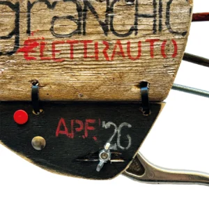 Dettaglio del guscio in legno di recupero della scultura a granchio con la scritta dipinta GRANCHIO ELETTRAUTO A.P.F. '26 e giunzioni metalliche