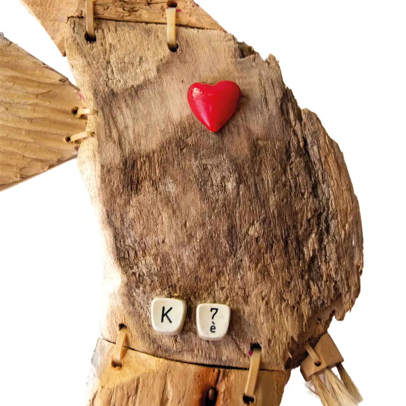 Dettaglio del corpo in legno di un cavalluccio marino scultura con applicazione di un cuore rosso e tasti vintage recanti K e 7è