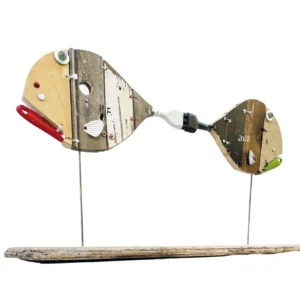 Scultura in legno e materiali di recupero raffigurante due pesci siamesi uniti dalla coda su basamento in legno