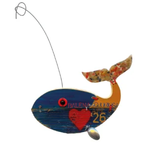 Scultura in legno a forma di balena intitolata Balena Cuoriosa con cuore rosso dipinto, pinna inferiore a cucchiaio e antenna a filo metallico