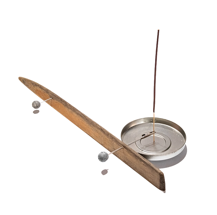 bilanciato Porta incenso artigianale realizzato con un'asta di legno in equilibrio su una base circolare in metallo