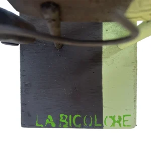 Dettaglio dall'alto della base in legno dipinta a metà marrone e metà verde chiaro con la scritta a pennello La Bicolore
