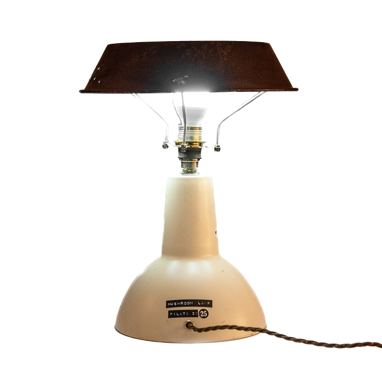 mushroom lamp Lampada da tavolo a forma di fungo con base chiara, paralume in metallo arrugginito e l'etichetta Mushroom Lamp Pilato del 2025