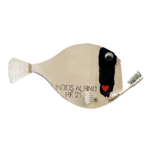 Scultura sagomata a forma di pesce bianco con la scritta Indios Albino P.F. 21 e un uno spazzolino da denti sulla parte anteriore