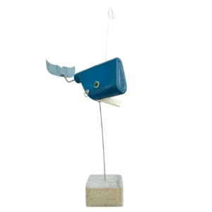 Vista di traverso della scultura a balena in flacone di plastica blu con pettine come denti e coda in lamiera sagomata